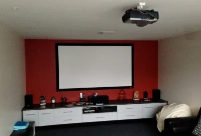 Projector and screen installed in a darkened home cinema room